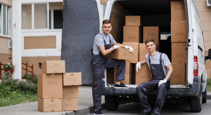Two moving company workers sitting in the back of a truck